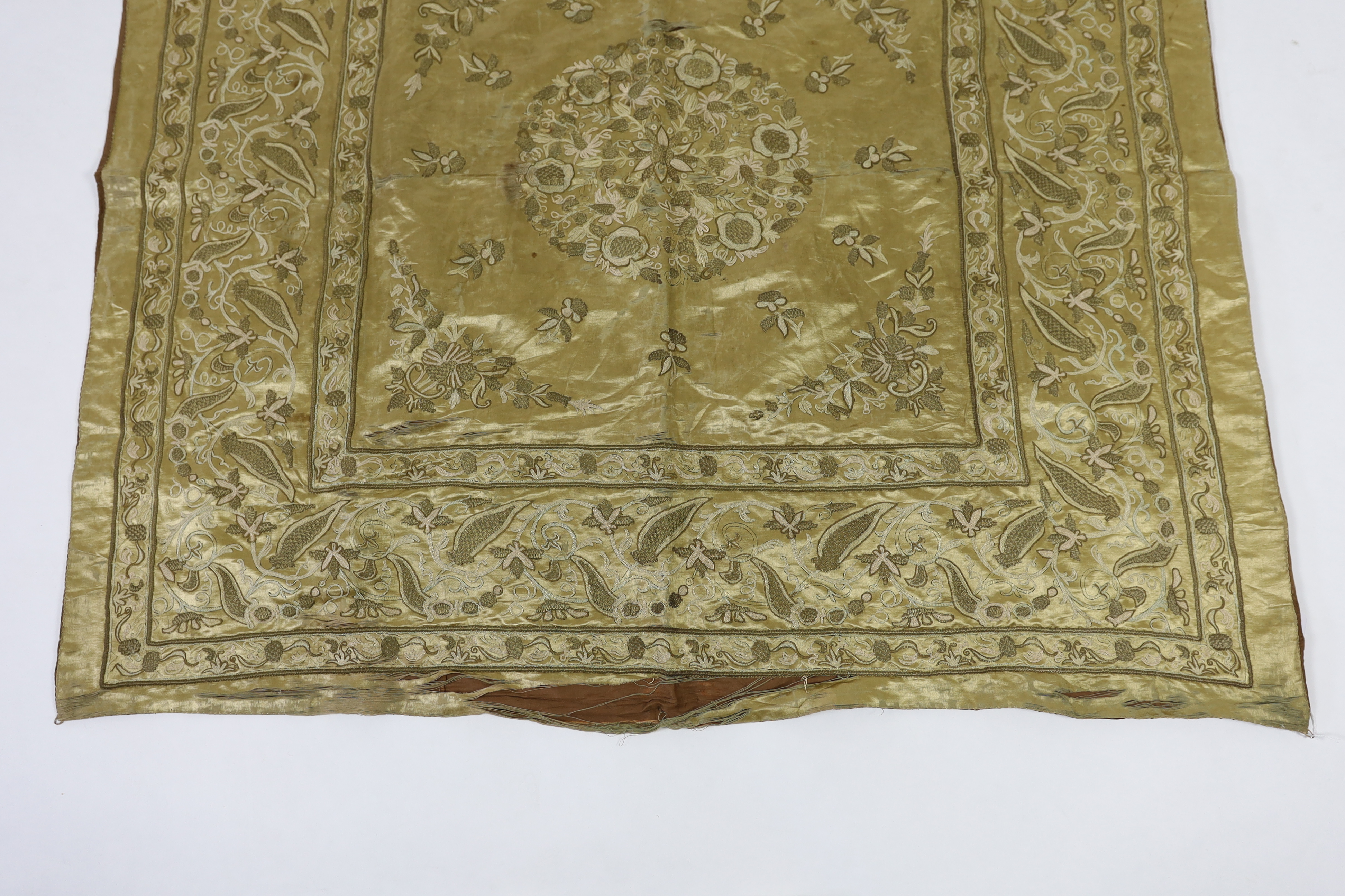 A late 19th century Turkish metallic thread and chain stitch silk satin cover, embroidered with a central cartouche of flowers and print, with rows of various borders with similar embroidery, 123 x 116cm